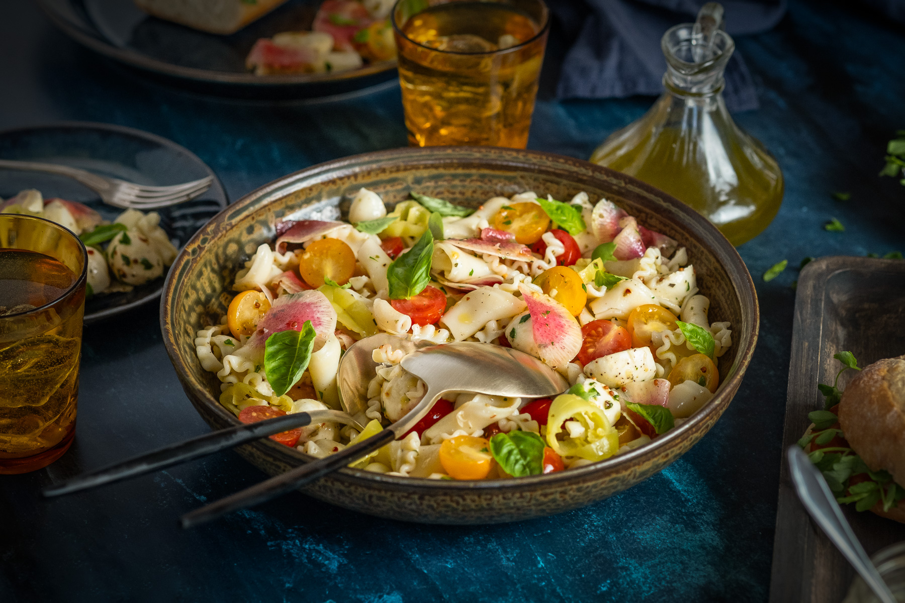 bowl of pasta salad on a dark blue surface styled by Catrine Kelty, photographed by Ling Messer
